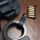 Handcuffs, ammunition, and firearm part beside a Minimalist Cuff Holder