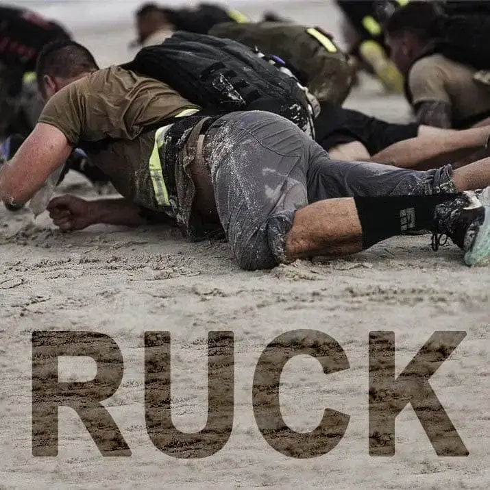 People exercising on sand with RUCK text, showcasing MudGear Ruck Sock for die-hard ruckers