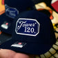 Navy blue baseball cap with Tower 120 patch and square passport cursive lettering design