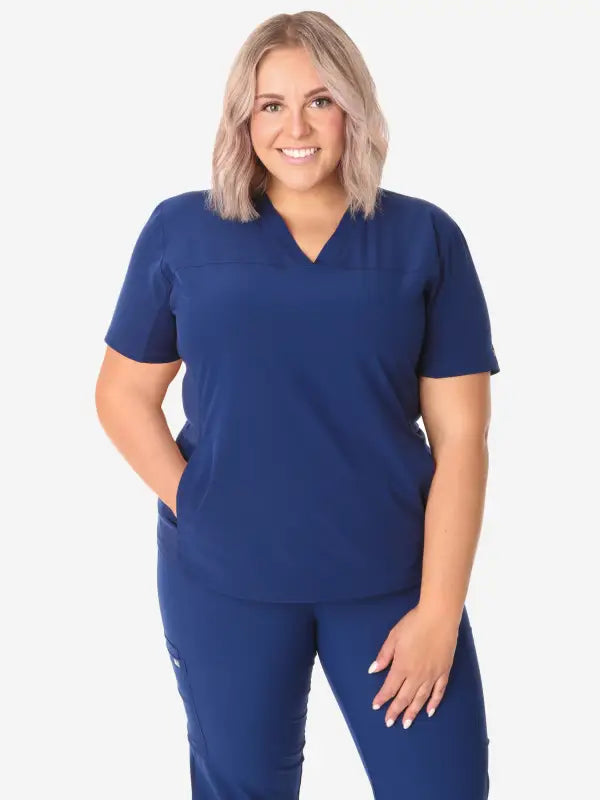 Navy blue women’s stash-pocket scrub uniform with v-neck top and matching pants