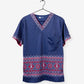 Navy blue V-neck holiday sweater scrub with red geometric border and polka dots