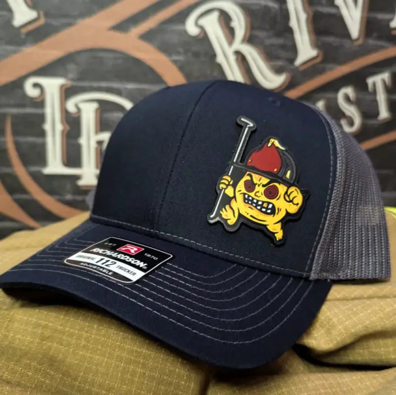 Navy and gray trucker hat with cartoon firefighter leather patch for first responders