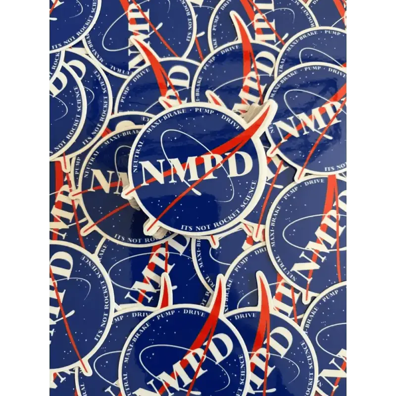 Overlapping navy blue NMPD logo patches for first responders in red and white accents
