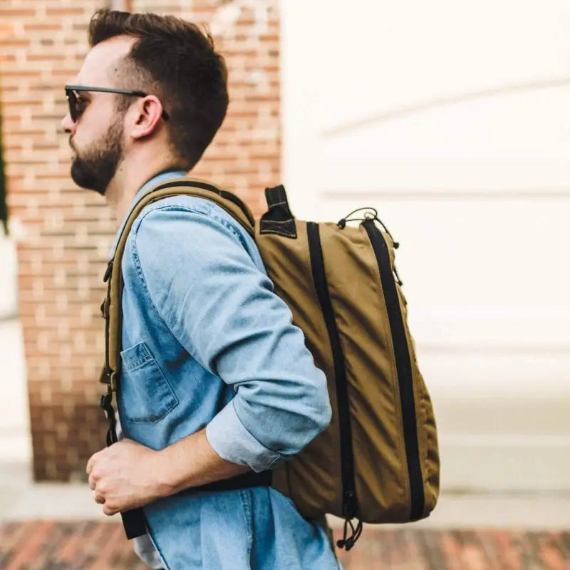 Olive-colored backpack worn with light blue denim shirt, showcasing 12HR Plus Royal Blue design