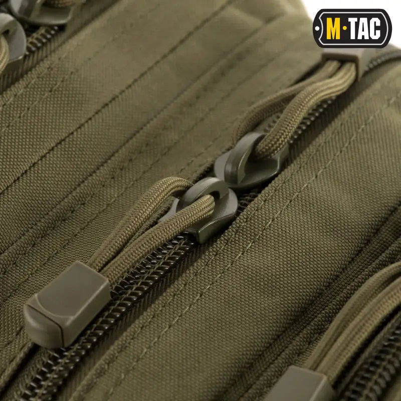 Olive-colored tactical zipper with cord pulls on M-Tac Assault Pack fabric