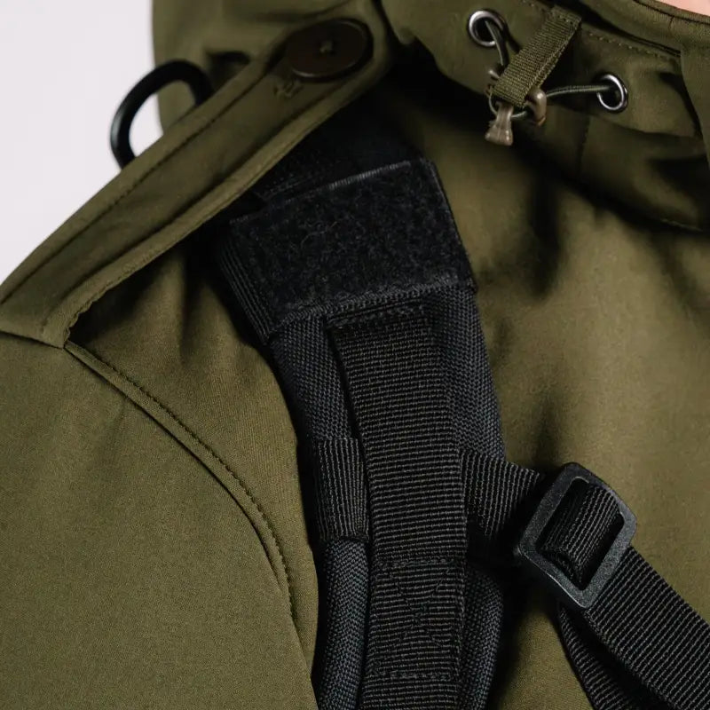Olive green Tactical Jacket Alpha with a hand pocket and black backpack strap