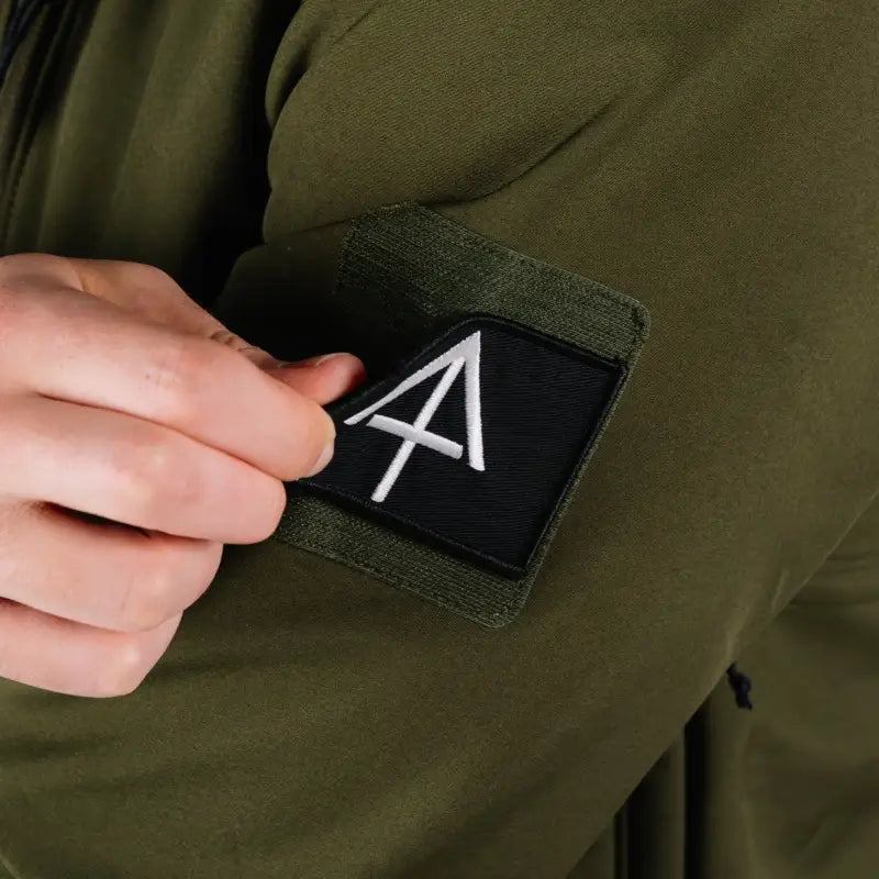 Olive green Tactical Jacket Alpha with patch and convenient hand pocket for outdoor use