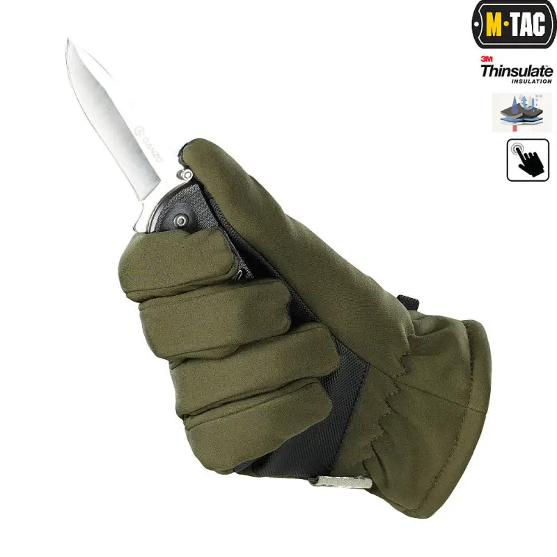 Olive green M-Tac Gloves Soft Shell Thinsulate holding a knife blade in winter setting