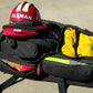 Open black duffel bag with firefighter helmet, zipper pockets, and hand grips for wildland gear