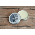 Open tin of Ol’ Fashion Beard Balm featuring a skull logo design on the lid
