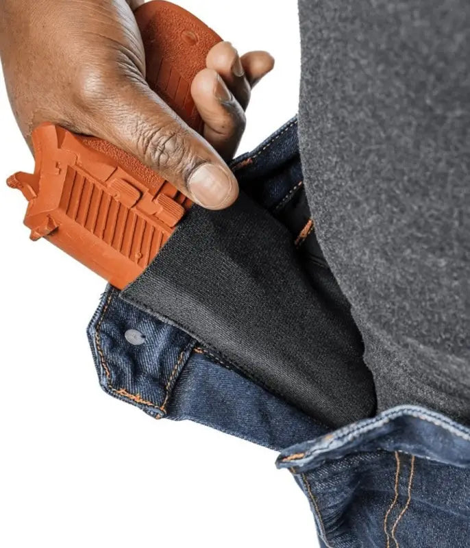 Orange holster on blue jeans showcasing Asset Tactical Jeans for superior functionality