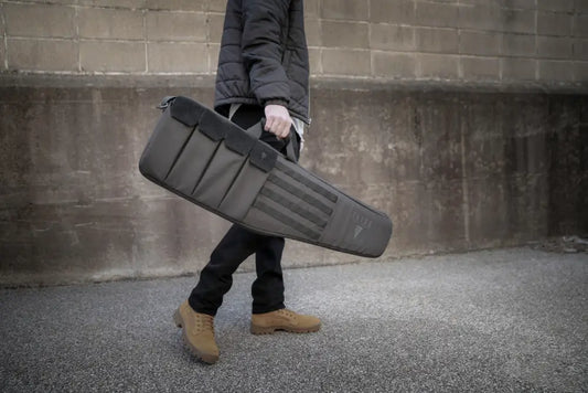 Gray padded tactical rifle case with durable construction, carried with a shoulder strap