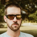 Person in amber-tinted sunglasses and grey t-shirt wearing Metel M30 Safety Sunglasses