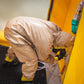 Person in beige hazmat suit using DS-1 Portable Decontamination Shower for disinfection