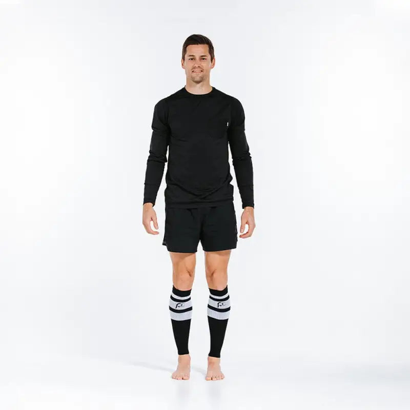 Person in black athletic attire wearing Black Classic Stripe calf compression sleeves