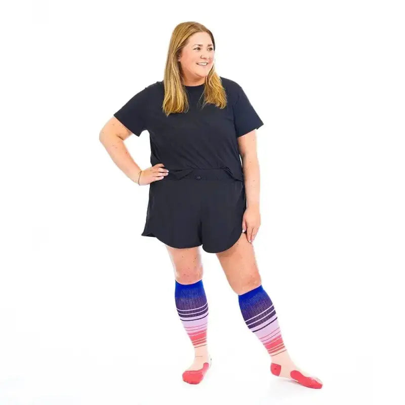 Person in black romper and colorful striped knee socks from Marathon Wide-Calf Florida Skies