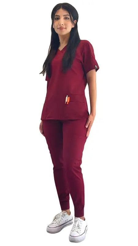 Person in burgundy Women’s 4-Way Extreme Stretch Jogger Scrubs with white sneakers