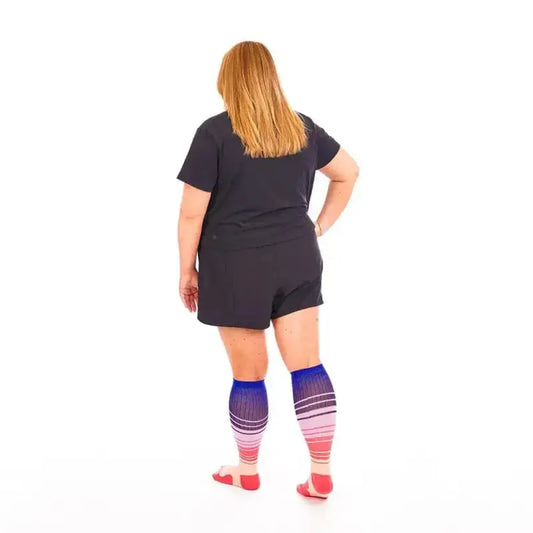 Person in Marathon Wide-Calf Florida Skies socks with a black romper, ideal for first responders