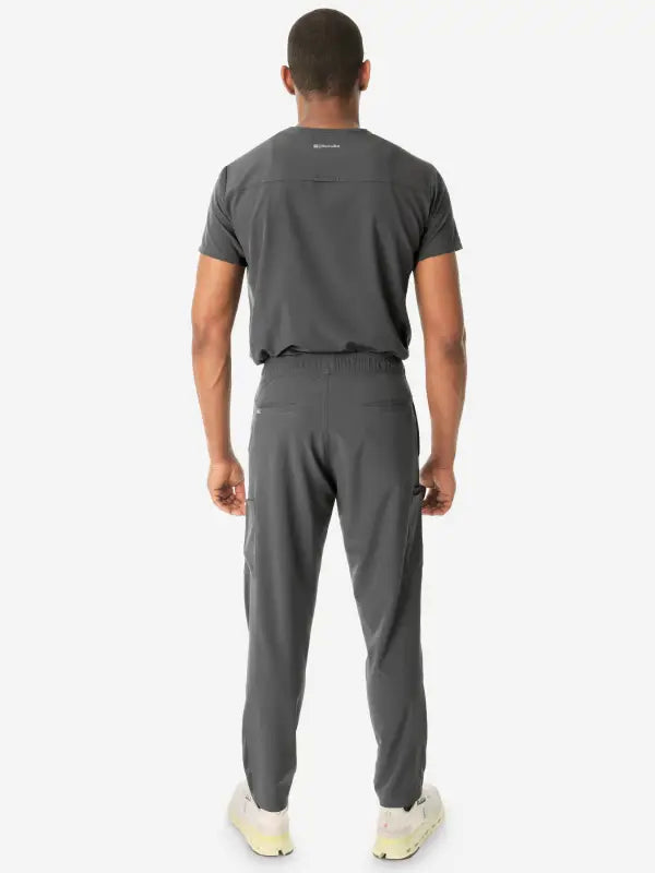 Person in gray athletic outfit showcasing Men’s Double-Pocket Scrub Top