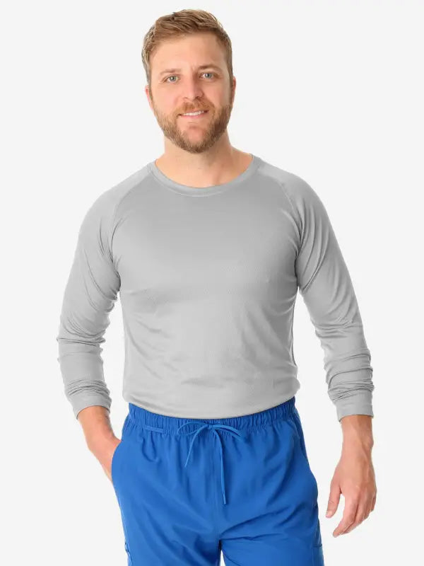 Person wearing gray men’s long-sleeve underscrub with bright blue shorts