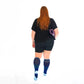 Person with long red hair in black attire and blue striped knee socks, showcasing Navy Blue Lines