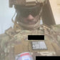 Person in military camouflage with tactical gear and canned beverage from Crusader 2.0 body armor kit