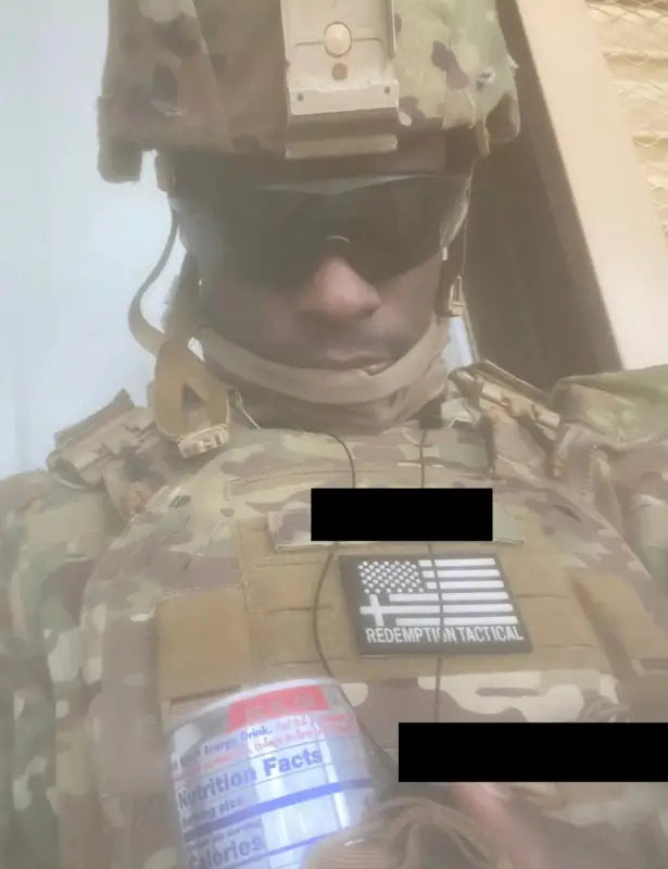 Person in military camouflage with tactical gear and canned beverage from Crusader 2.0 body armor kit