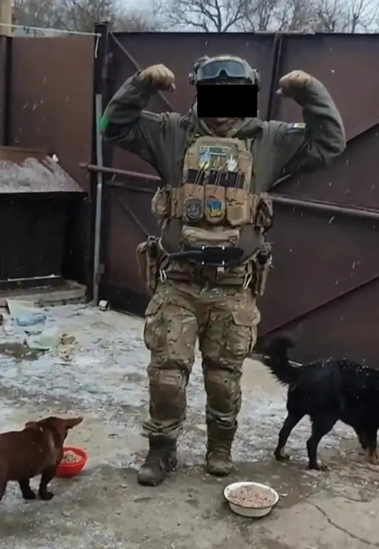 Person in full body armor tactical gear with two dogs and food bowls for large size protection