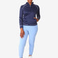 Person in navy blue women’s scrub jacket, light blue pants, and white sneakers