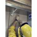 Person in yellow safety gear working on elevator control panel for Williams Wedge
