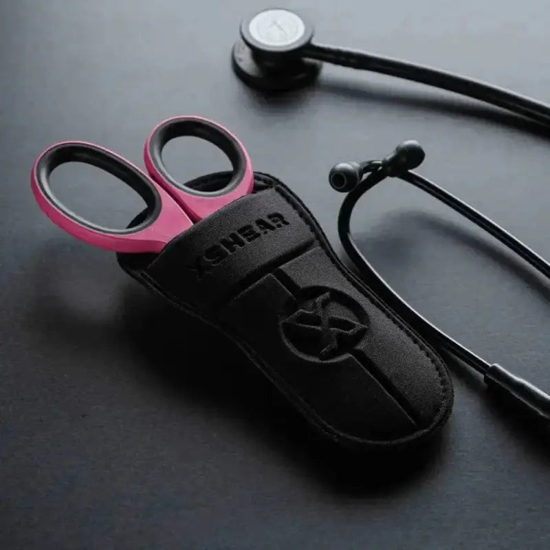 Pink-handled trauma shears in a black leather holster with black titanium coated blades