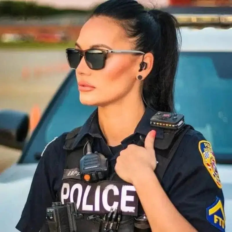 Police officer in sunglasses and tactical gear showcasing NADO Ghost for first responders