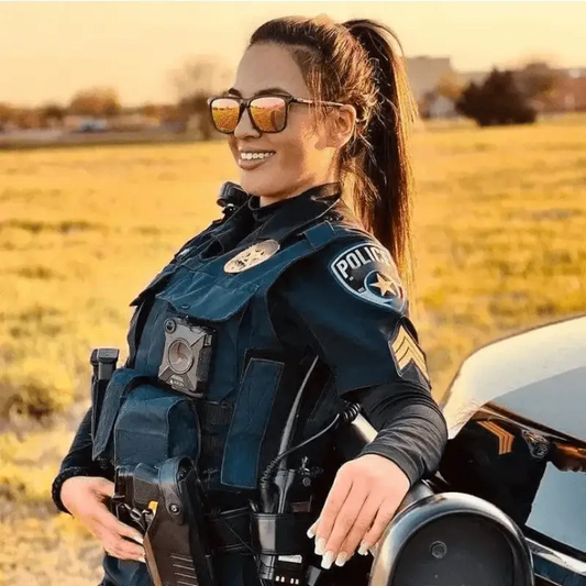 Police officer in tactical vest and sunglasses next to motorcycle at NADO Sunset event