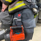 Red battery-powered rescue tool on a firefighter’s truck belt with Flashlight Strap-FFFS