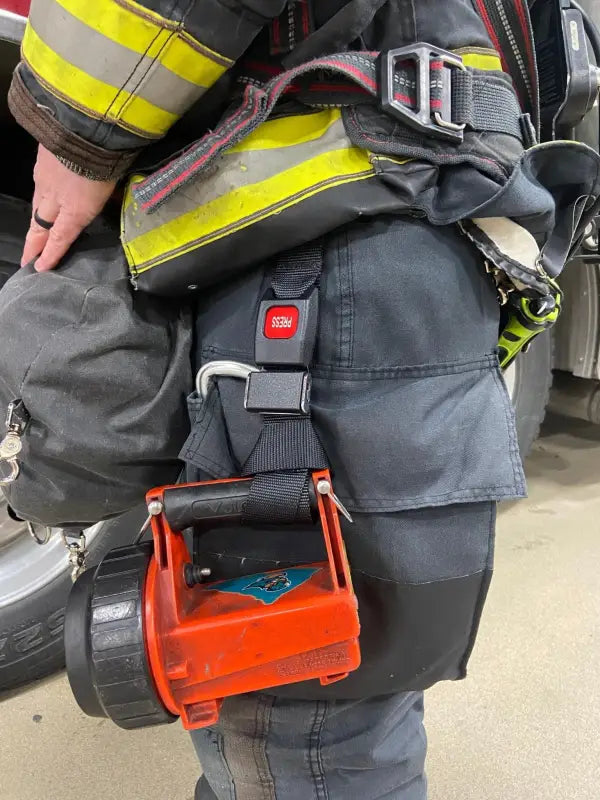 Red battery-powered rescue tool on a firefighter’s truck belt with Flashlight Strap-FFFS