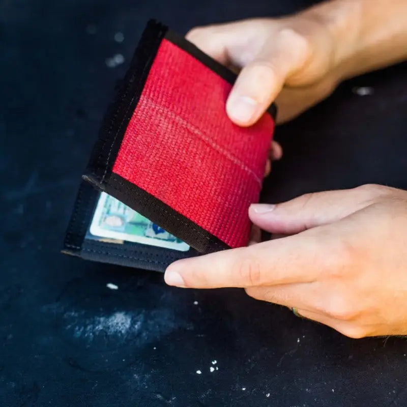 Red and black leather wallet opening, showcasing Coyote Combat Leather durability