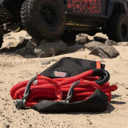 Red and black kinetic recovery rope coiled in Off-Road Recovery Kit on the ground