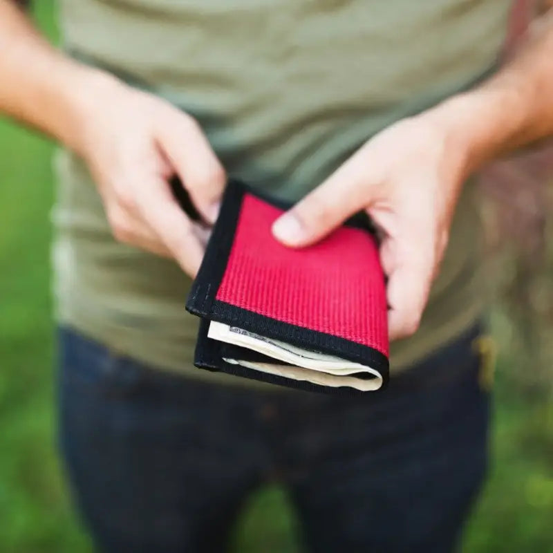 Red and black wallet with cash in Coyote Combat Leather for style and durability