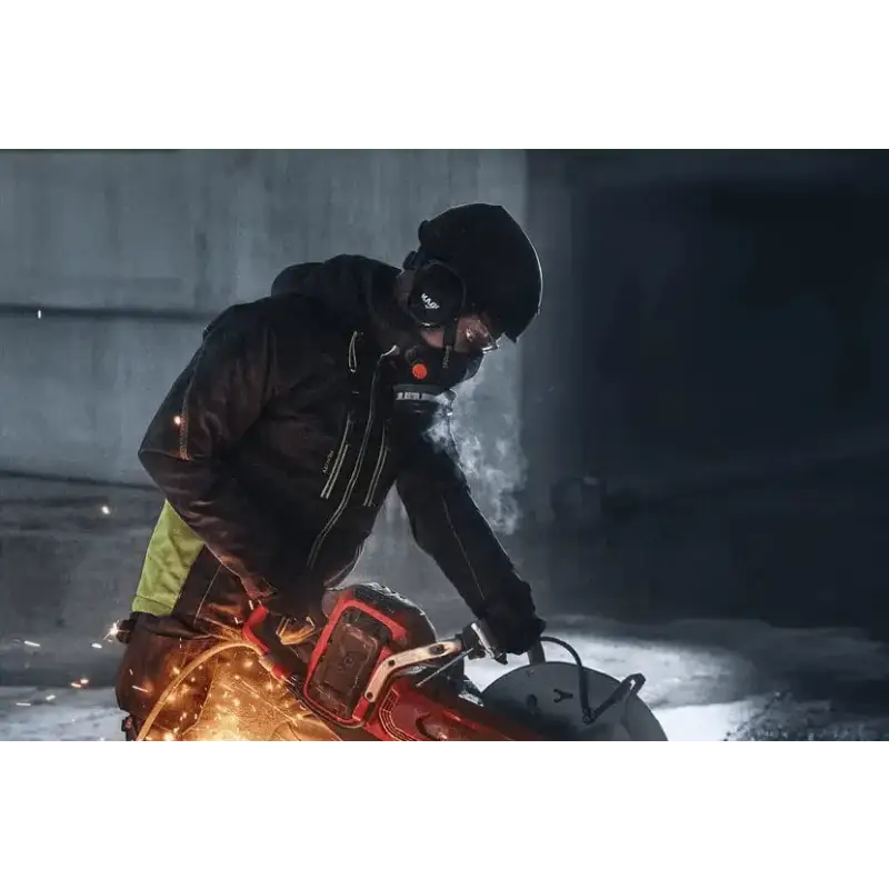 Red chainsaw creating sparks in winter, showcasing Husqvarna K 1 PACE battery powered cutter