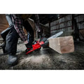 Red Milwaukee 2727-20C M18 FUEL™ 14’’ Chainsaw cutting through wooden beam