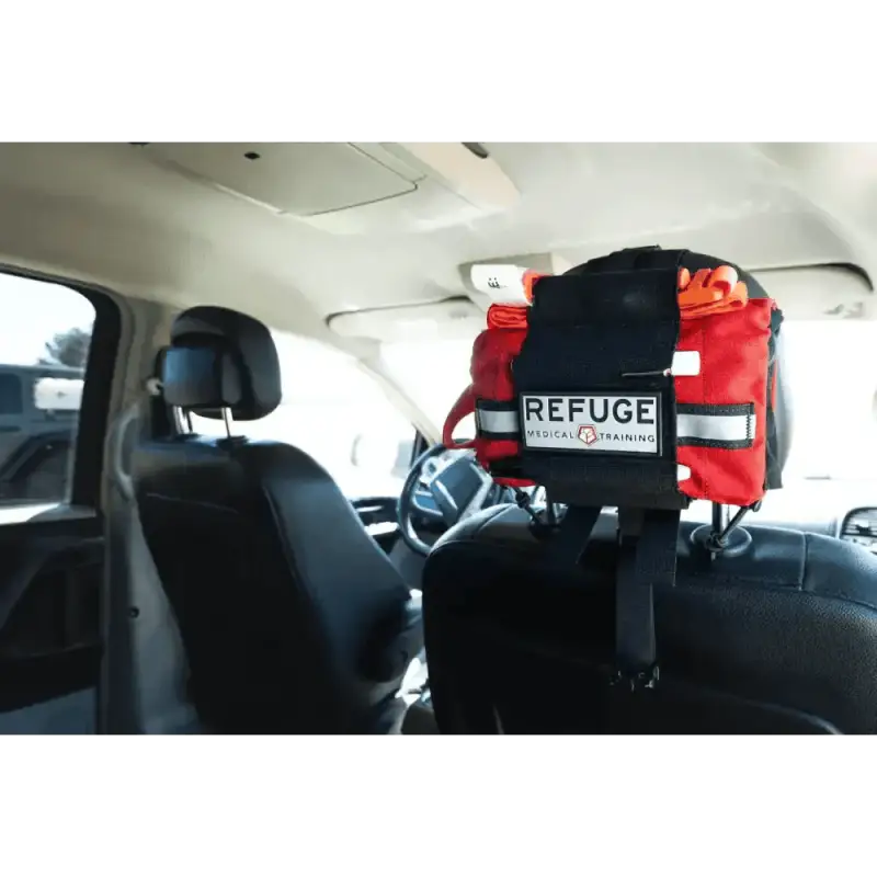 Red emergency medical Refuge pack in Travel FAK mounted between car headrests