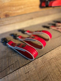 Red hair clippers for first responders with glove straps lined up in a row