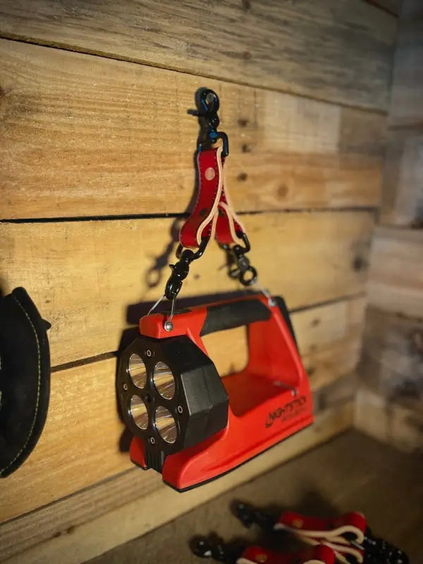 Red LED flashlight hanging from hook on a Box Light Clip for convenient storage