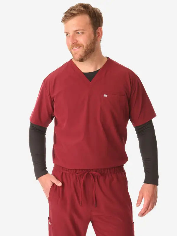 Red men’s double-pocket scrub uniform with layered dark long sleeves underneath