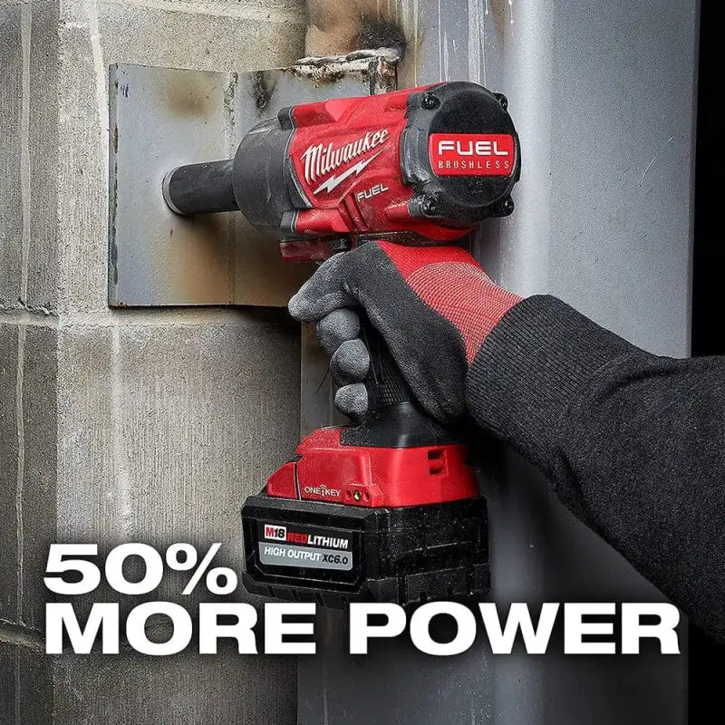 Red Milwaukee FUEL cordless power drill with gloved hand and REDLITHIUM HIGH OUTPUT XC6 battery