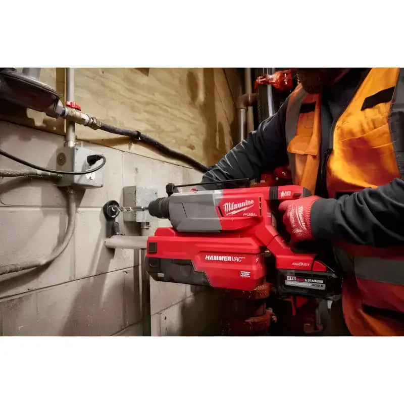 Red Milwaukee 2916-20 M18 FUEL D-Handle Rotary Hammer drilling into a pipe