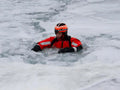 Rescue worker in red suit using ARM-LOC Rescue System for water rescues and victim pulls