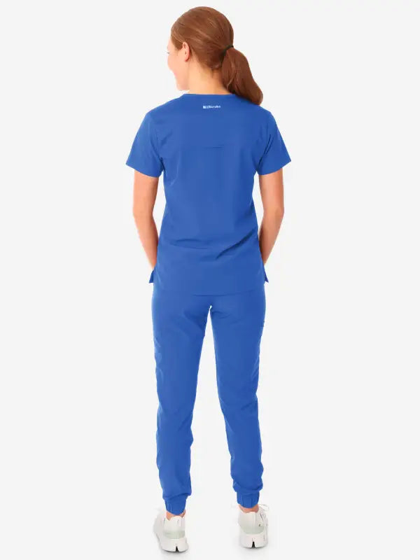 Royal blue women’s tuckable one-pocket scrub top with short sleeves, back view