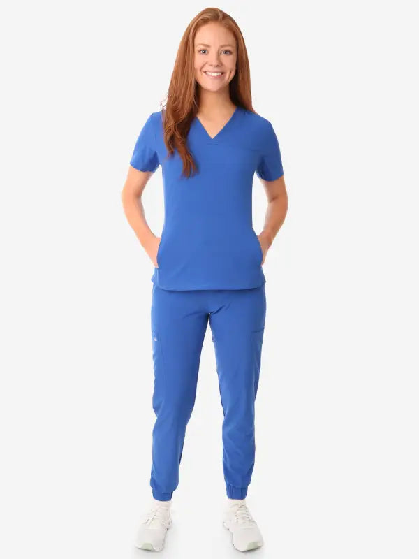 Royal blue women’s stash-pocket scrub with white sneakers for a stylish medical look