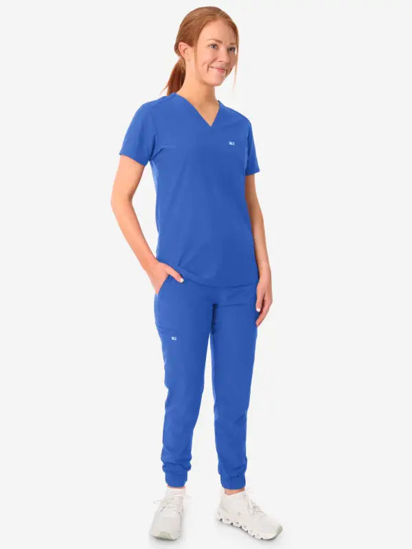 Royal blue women’s tuckable one-pocket scrub uniform with jogger-style pants and v-neck top